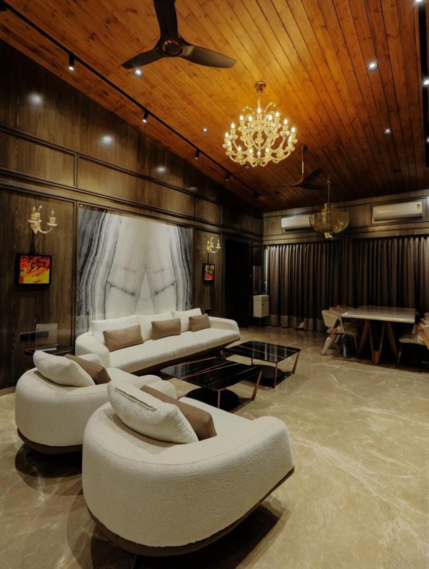 Warm timber-panelled lounge with a curved sofa beneath a sculptural pendant light.