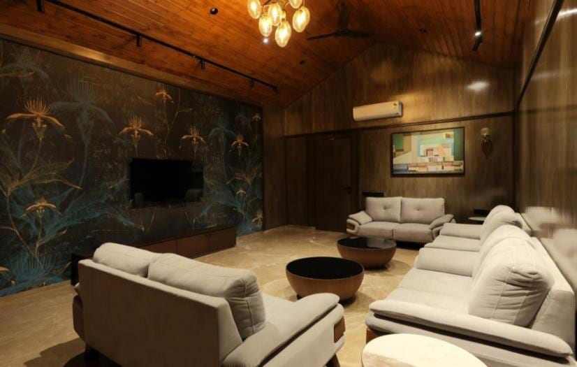 Lounge with a textured stone feature wall, framed art and upholstered sofas.