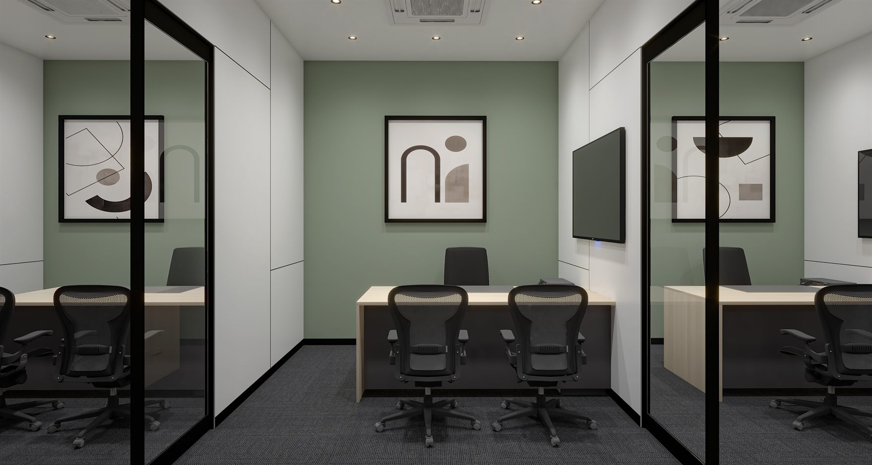 Two glass-partitioned cabins with light timber desks, black mesh chairs, a sage-green accent wall, abstract framed art and a wall-mounted screen on grey carpet