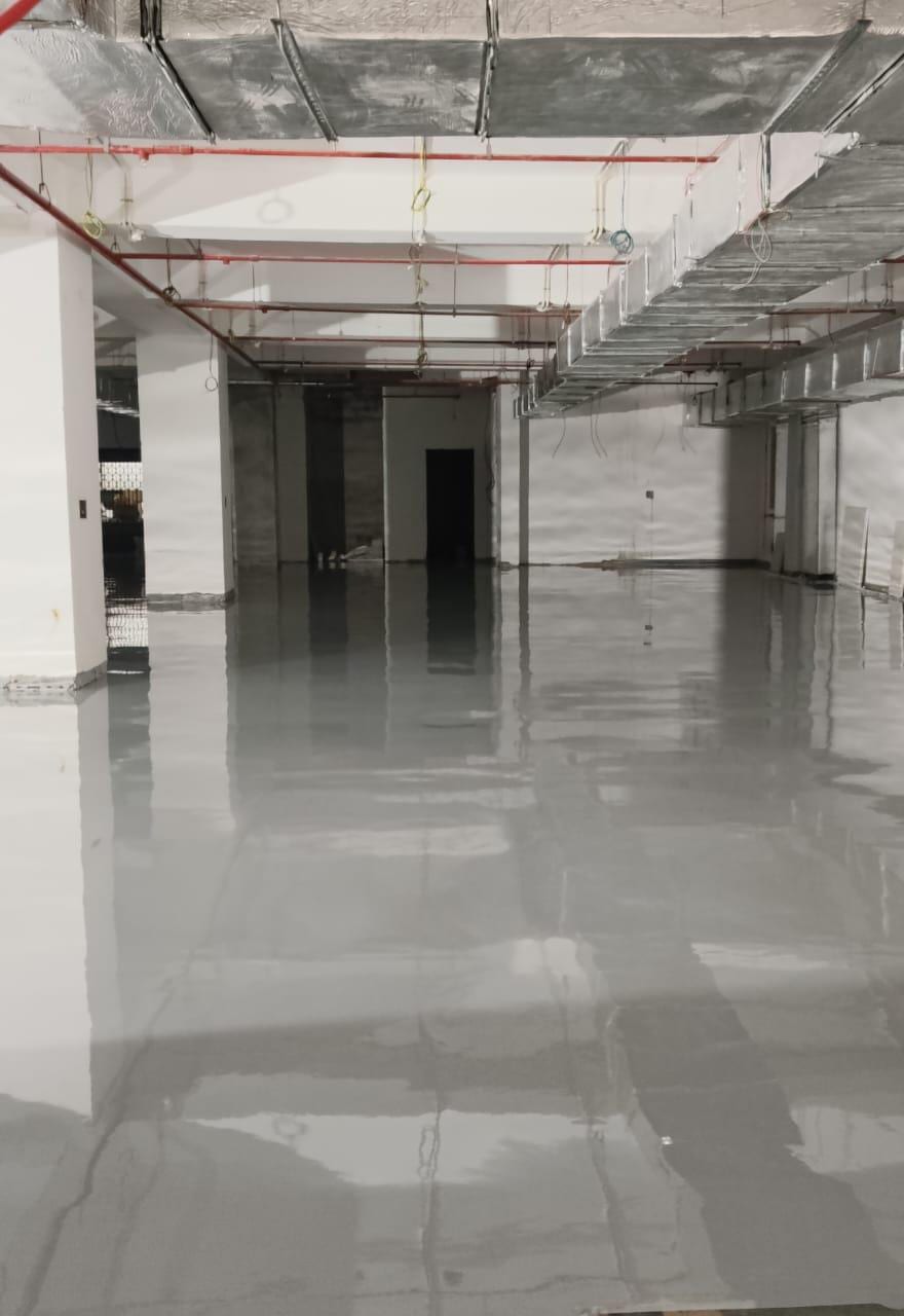 Open office floor awaiting fit-out, lined with bare structural columns.