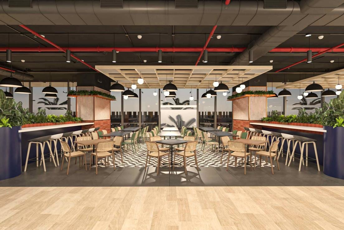 Communal dining hall with long shared tables, banquette seating and exposed industrial ceiling services.