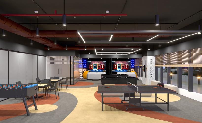 Games and recreation zone with table tennis, foosball, gaming screens and colourful patterned flooring.