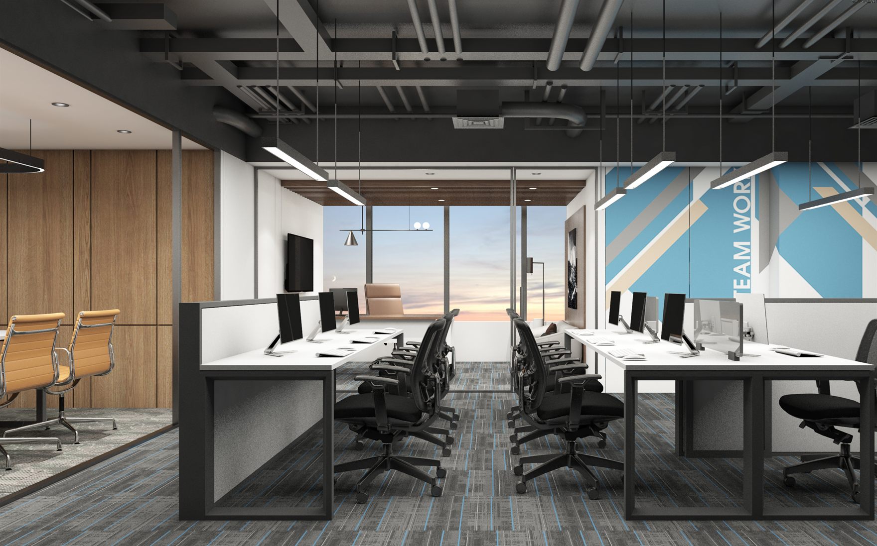 Open workstation area with white benching desks, black mesh chairs, exposed services ceiling and a blue Team Work graphic wall